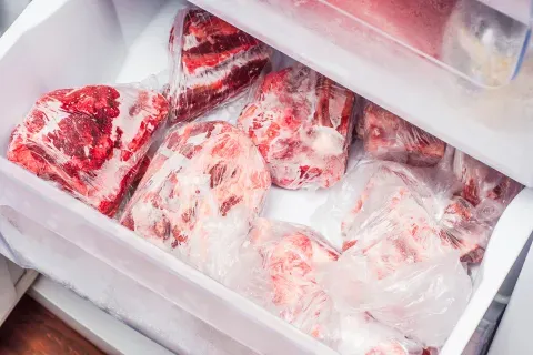  A refrigerator filled with various cuts of meat, showcasing a well-organized and stocked interior.